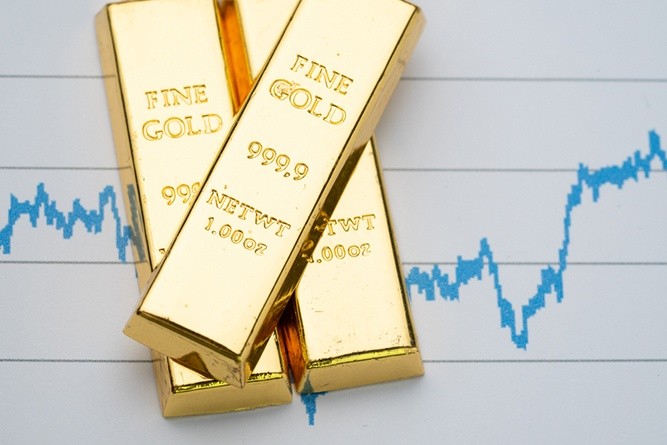 Wibest – Spot gold prices: Gold bars stacked up top of a chart.