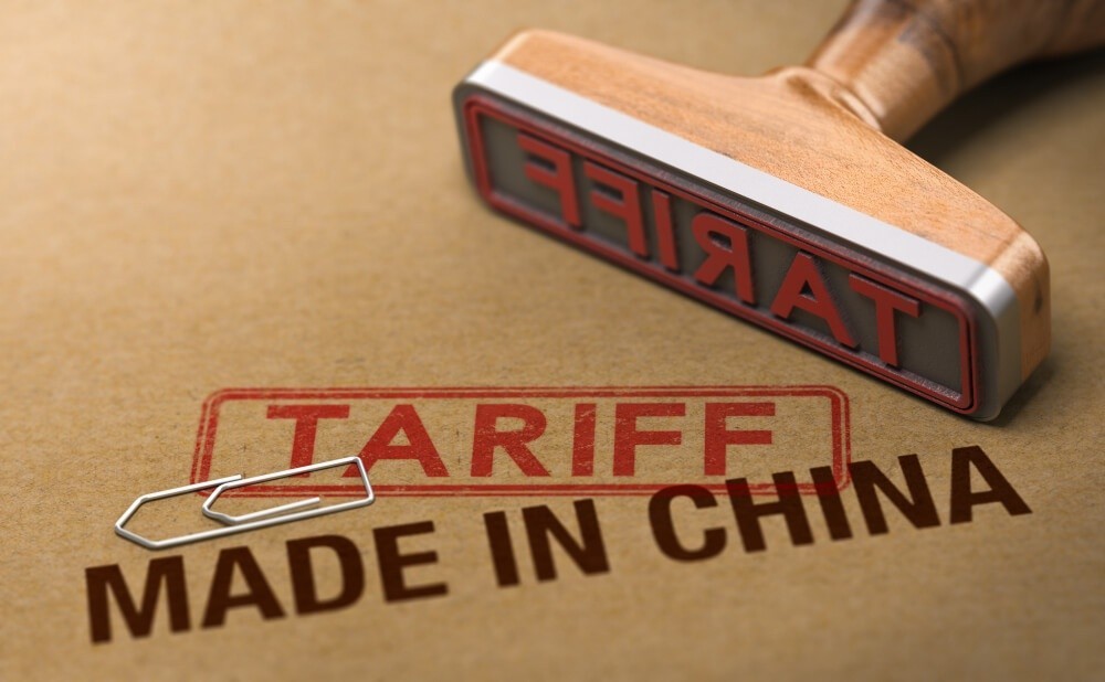 Rubber stamp over cardboard background with the words made in China and tariff.