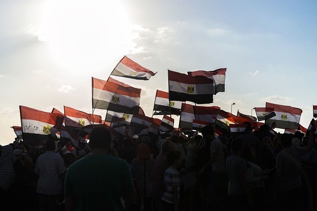 Wibest – IMF: Silhouettes of people holding Egyptian flags