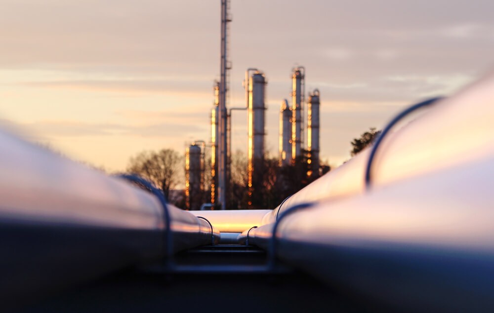 Sunset at crude oil refinery with pipeline network.